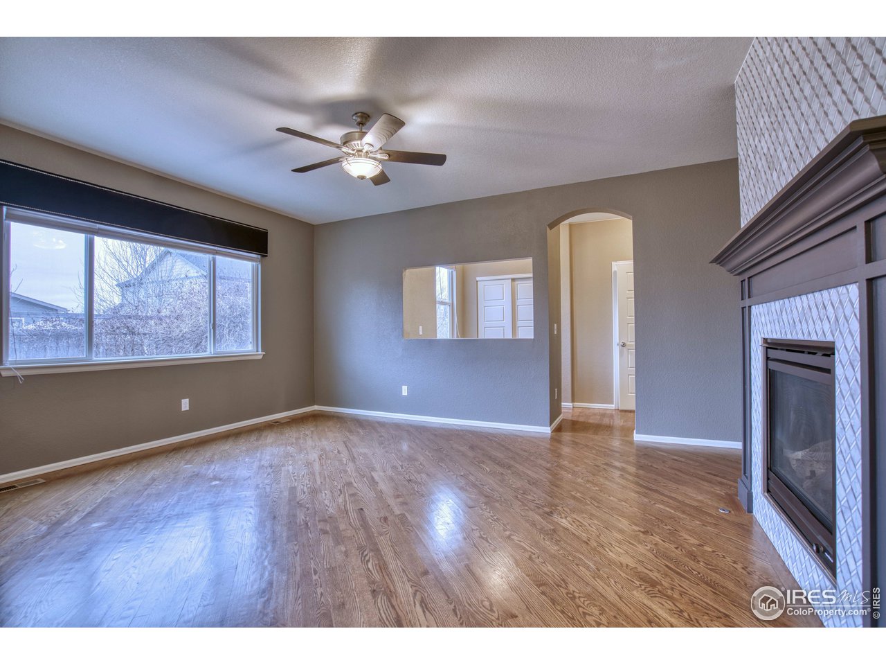 8552 Raspberry Drive Frederick, CO 80504 - Photo 13 of 40 a view of an empty room with a window and wooden floor