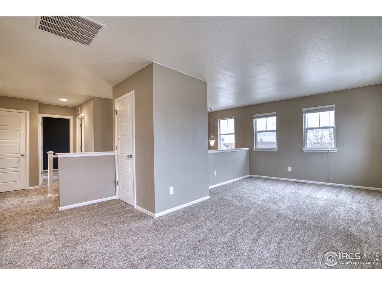 8552 Raspberry Drive Frederick, CO 80504 - Photo 22 of 40 a view of an empty room with window and wooden floor