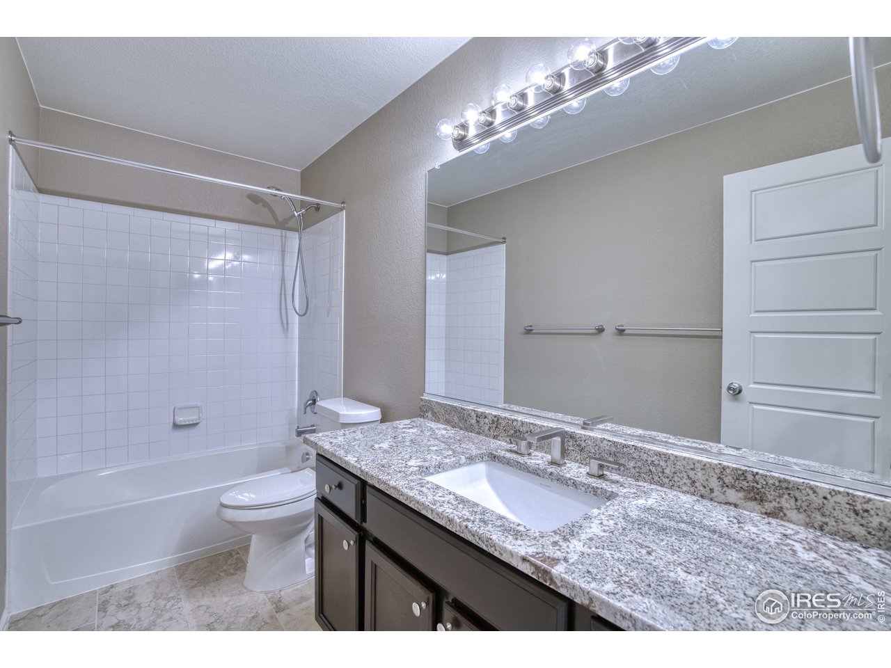 8552 Raspberry Drive Frederick, CO 80504 - Photo 25 of 40 a bathroom with a granite countertop sink a toilet a mirror and shower