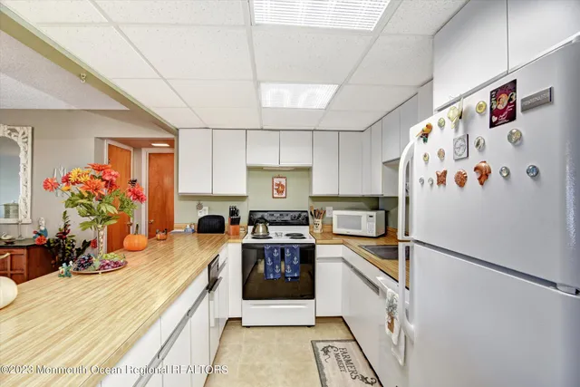 a view of a kitchen and dining area a chandelier fan table chair and wooden floor