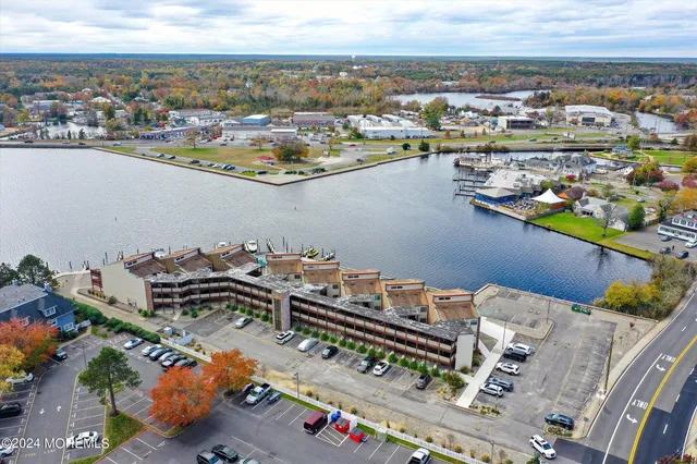 a view of a dining room with furniture a chandelier and large windows