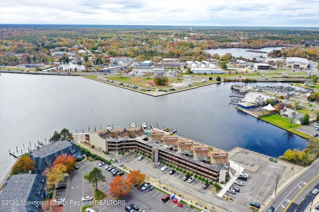 a view of a dining room with furniture a chandelier and large windows