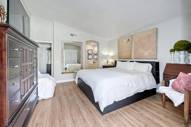 a bedroom with bed and wooden floor