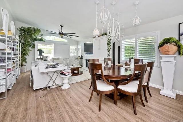 a dining room with wooden floor a chandelier a wooden table and chairs