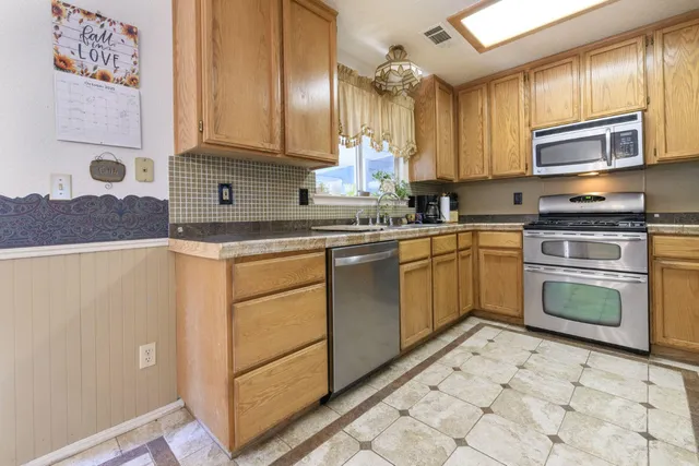 a kitchen with stainless steel appliances granite countertop a stove sink and cabinets