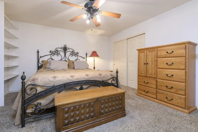 a spacious bedroom with a bed and a chandelier