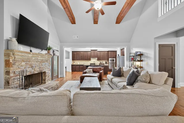 a kitchen with stainless steel appliances granite countertop a table chairs sink refrigerator and cabinets