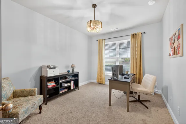 a kitchen with stainless steel appliances granite countertop a table chairs refrigerator and microwave