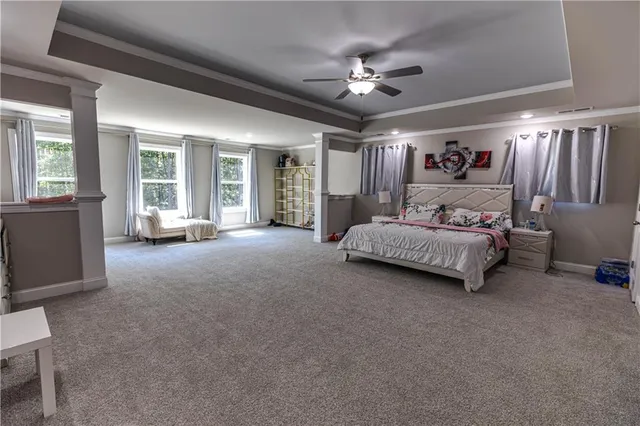 a spacious bedroom with a large bed and a chandelier