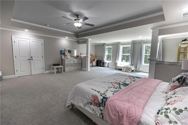 a spacious bedroom with a bed and ceiling fan