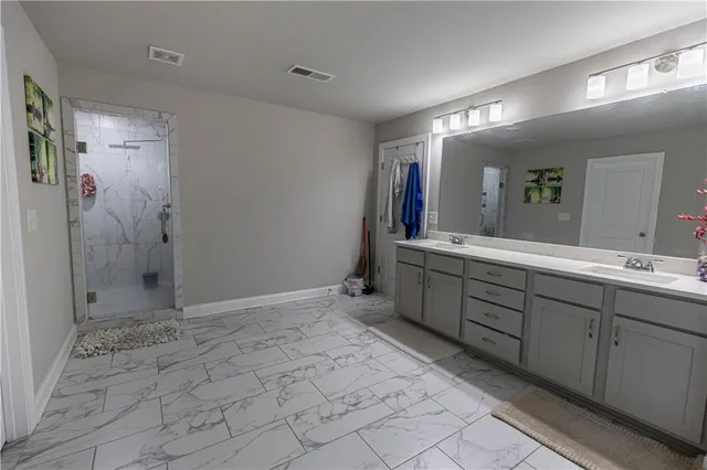 a spacious bathroom with a mirror sink and shower