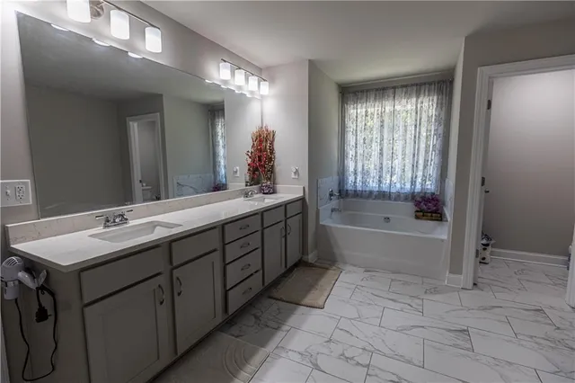 a bathroom with a tub sink and mirror