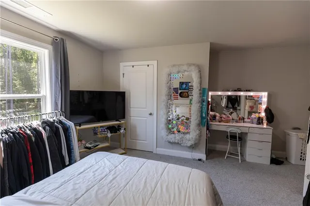 a bedroom with a bed and a flat tv screen on the dresser