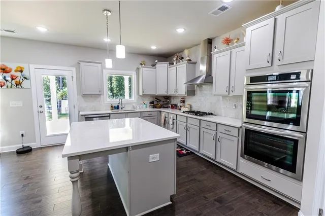 a kitchen with stainless steel appliances kitchen island granite countertop a stove a sink and a microwave