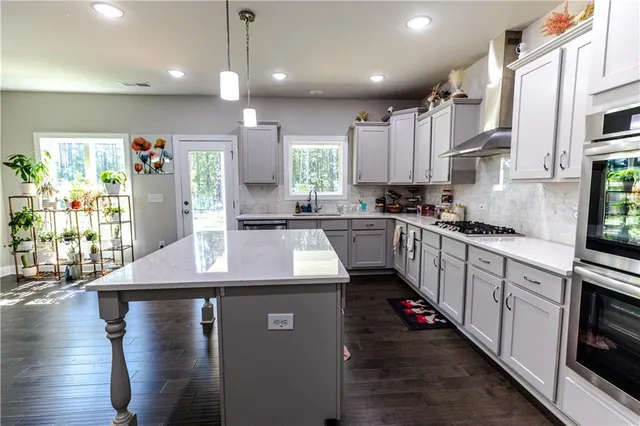 a kitchen with stainless steel appliances granite countertop a sink window and cabinets