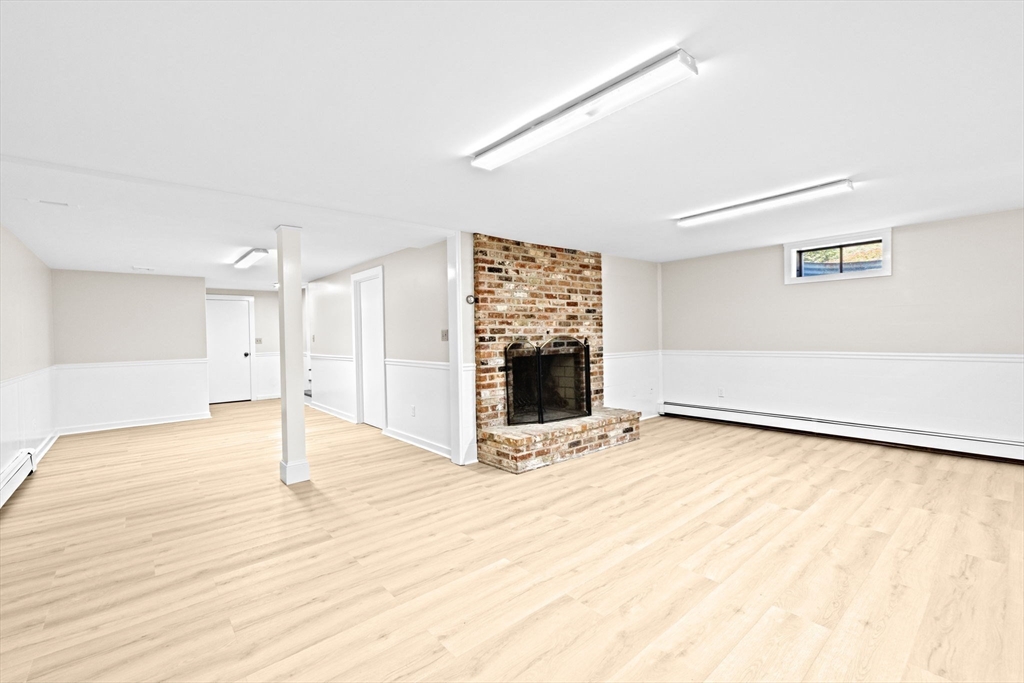 2 Windward Lane Scituate, MA 02066 - Photo 26 of 42 a view of an empty room with wooden floor and a fireplace