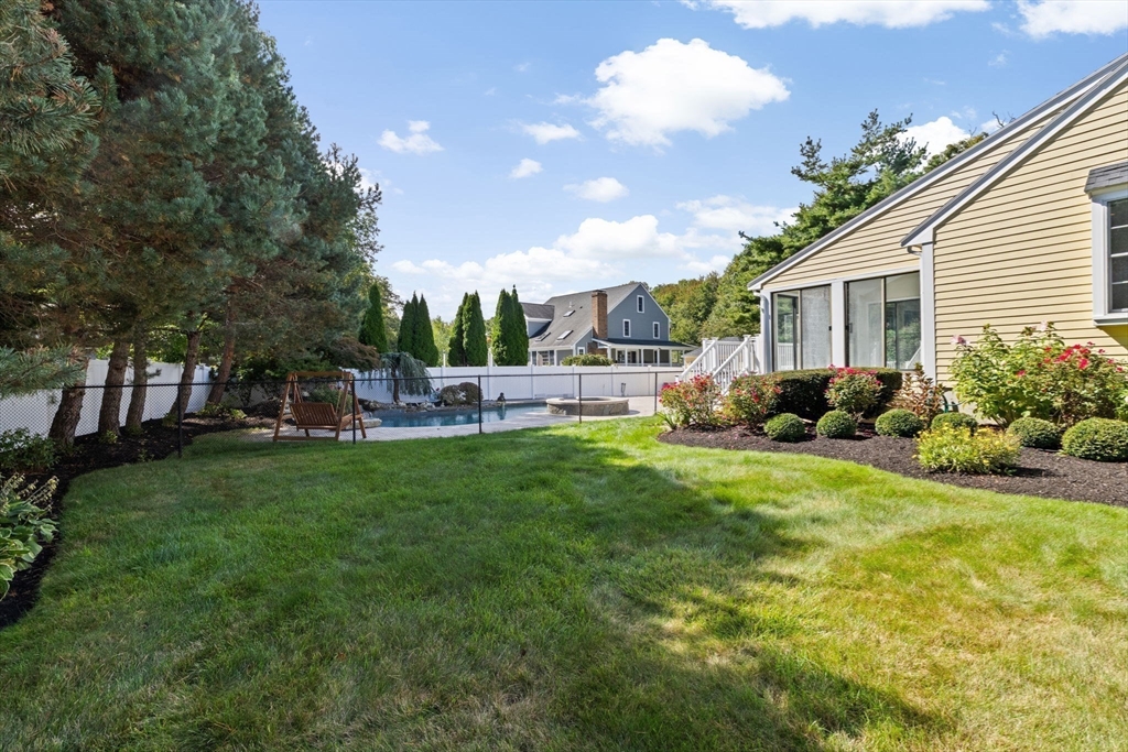 2 Windward Lane Scituate, MA 02066 - Photo 37 of 42 a backyard of a house with table and chairs plants and large tree