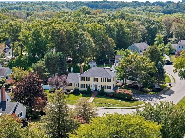 a front view of a house with a garden and lake view