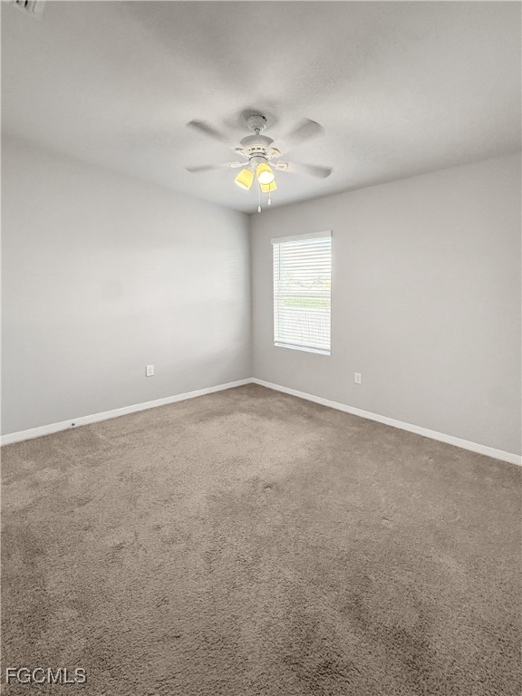 8357 Matanzas Road Fort Myers, FL 33967 - Photo 5 of 25 an empty room with windows and chandelier fan