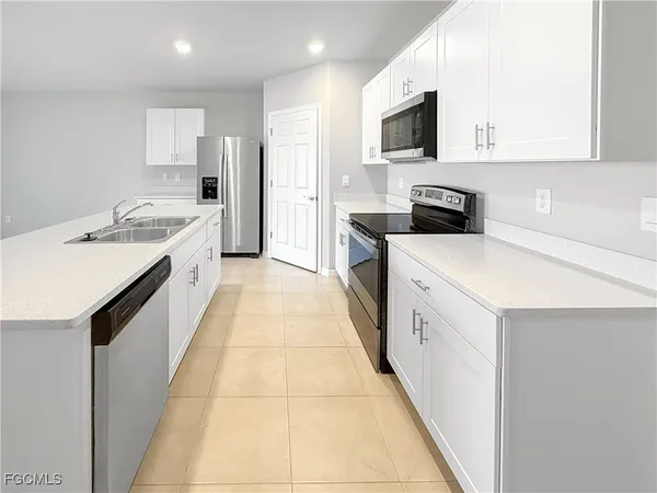 a kitchen with a sink stove top oven and refrigerator