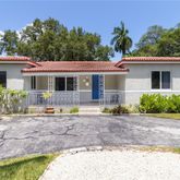 a front view of a house with a yard and potted plants