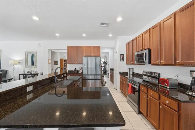 a large kitchen with stainless steel appliances granite countertop a lot of counter space and wooden floor