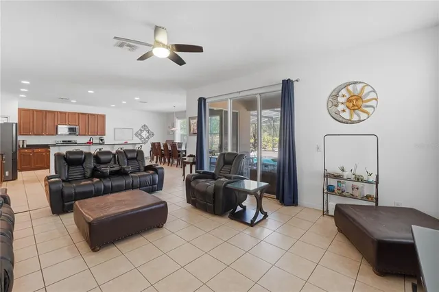 a living room with furniture kitchen view and a chandelier