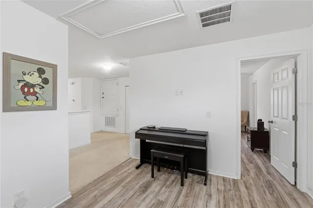 a hallway with a piano and wooden floor