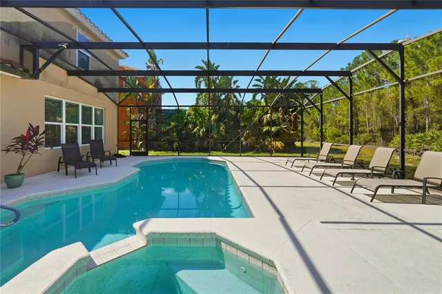 a view of a swimming pool with a patio and a yard