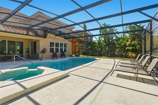 a view of a patio with a table and chairs under an umbrella with a barbeque