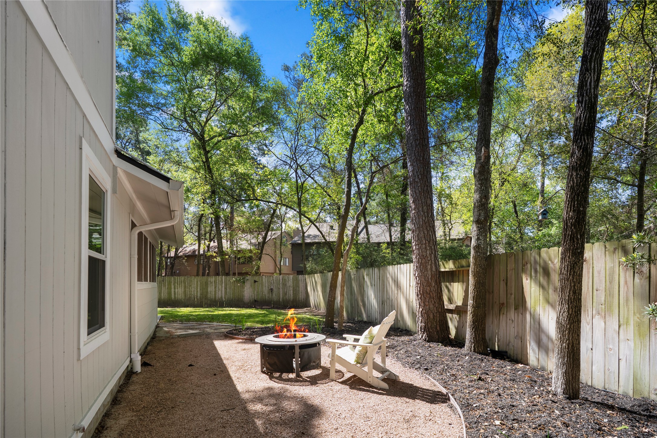 12224 Gun Oak Place Spring, TX 77380 - Photo 34 of 42 A peaceful outdoor nook ready for a fire pit, where conversations linger a little longer and memories are made under the trees.