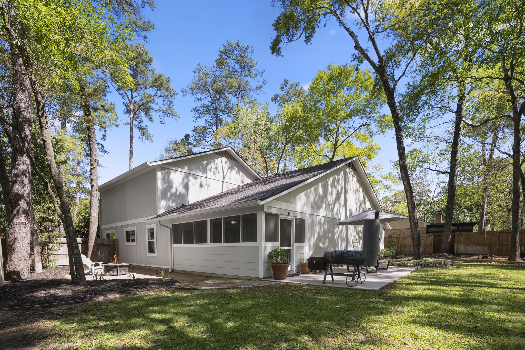 12224 Gun Oak Place Spring, TX 77380 - Photo 36 of 42 Rear view of the home showcasing the connection between indoor living and outdoor spaces designed for gathering and relaxation.