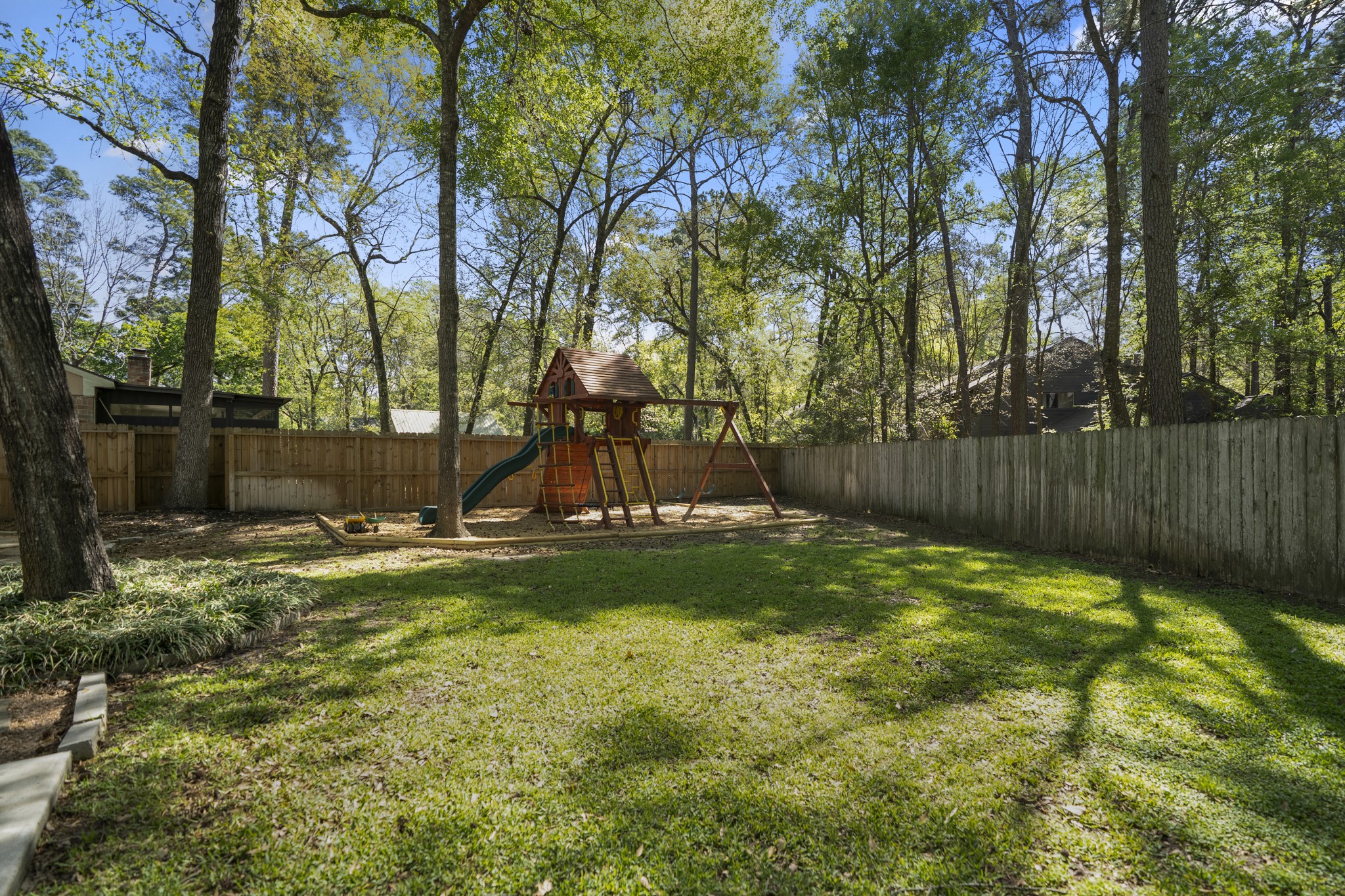 12224 Gun Oak Place Spring, TX 77380 - Photo 37 of 42 Spacious, tree lined backyard with a dedicated area for the Tree Frog swing set, which will remain with the property, creating a natural space for play, and enjoying the outdoors.