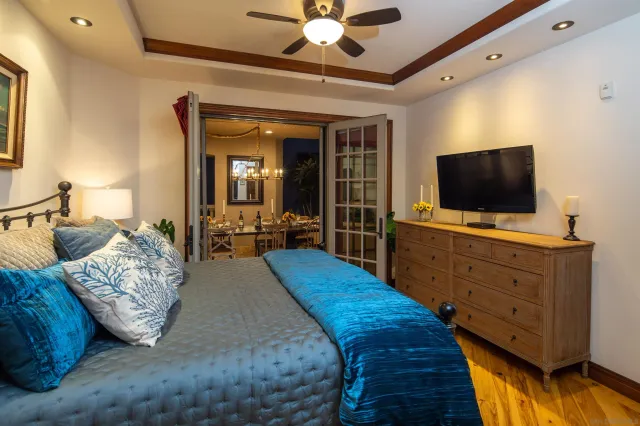 a spacious bedroom with a bed and a flat screen tv