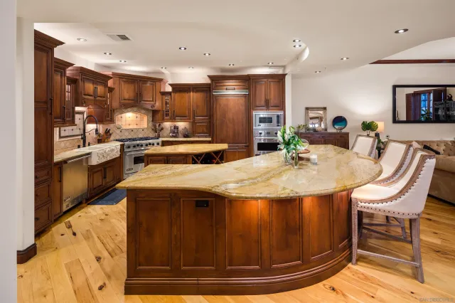 a kitchen with stainless steel appliances granite countertop a sink a stove and a refrigerator