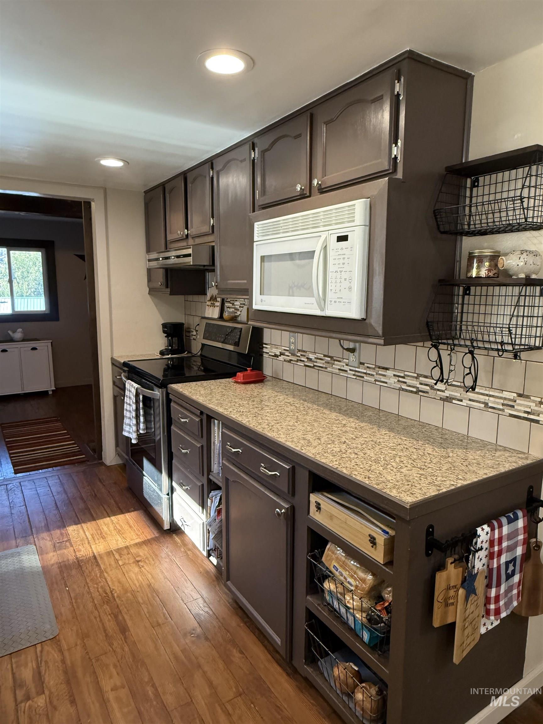 403 138th Street Orofino, ID 83544 - Photo 6 of 32 Kitchen with white microwave, stainless steel range with electric cooktop, wood-type flooring, light countertops, and recessed lighting