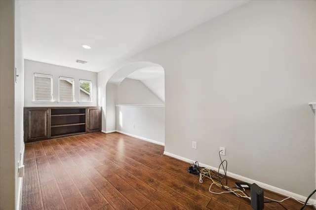 a view of an empty room with a fireplace and wooden floor