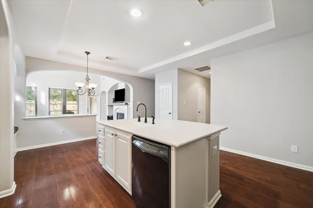a kitchen with a sink a window and wooden floor
