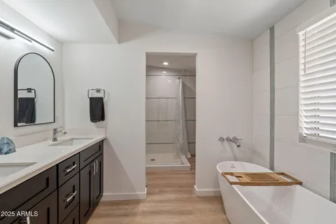 a bathroom with a tub a sink and mirror