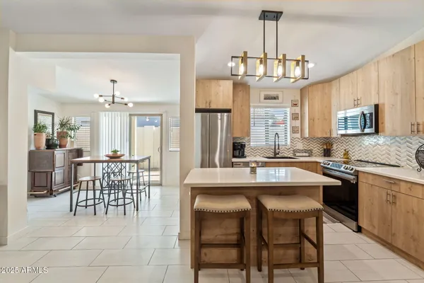 a kitchen with a dining table chairs sink and granite counter tops