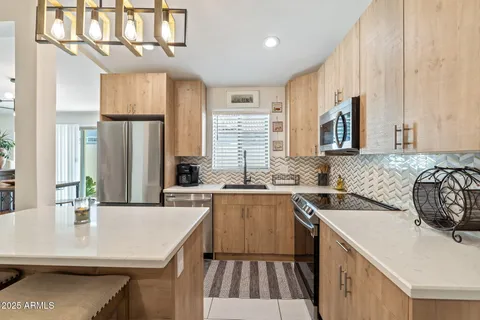a kitchen with a sink a stove a refrigerator and cabinets