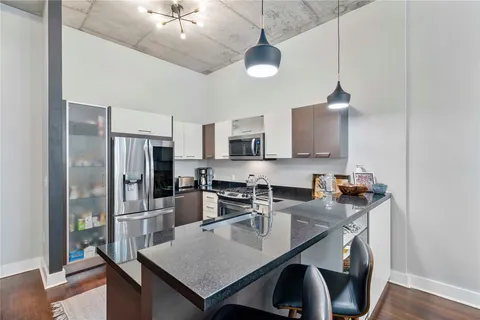a kitchen with stainless steel appliances granite countertop a sink a stove and refrigerator