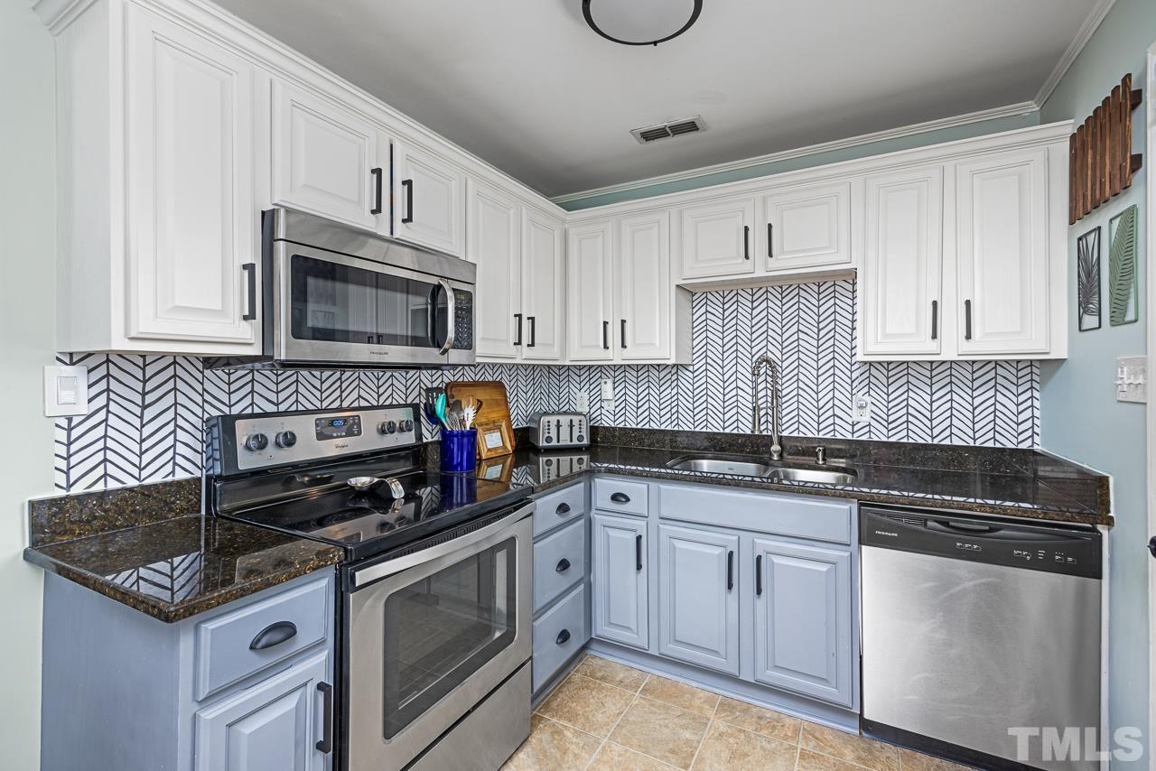 2458 Stevens Road Raleigh, NC 27610 - Photo 9 of 20 a kitchen with granite countertop a sink a stove and cabinets