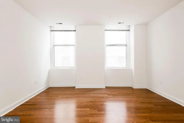 an empty room with wooden floor and a window