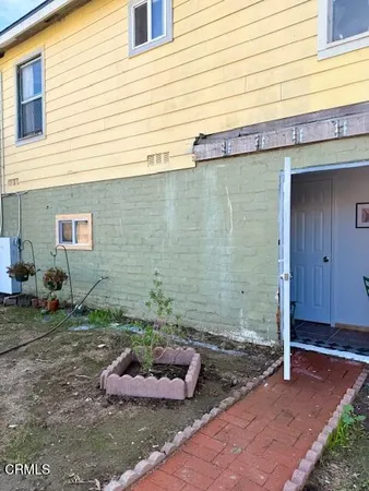 a view of a backyard with plants and entertaining space