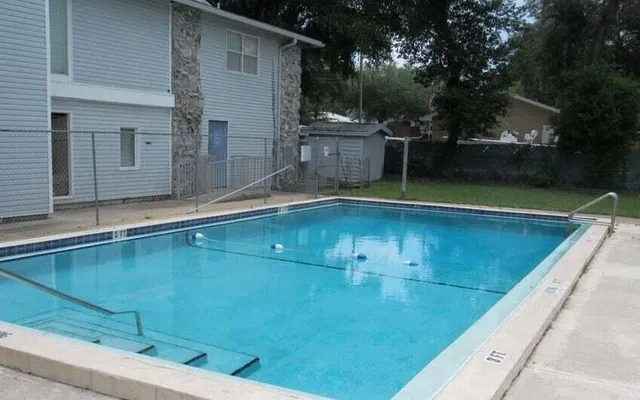 a view of a swimming pool with a chair and tables