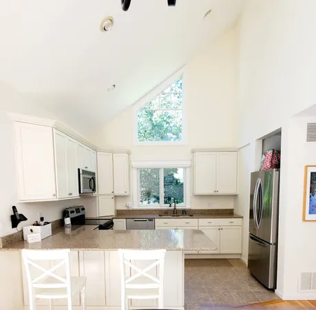 a kitchen with stainless steel appliances granite countertop a sink refrigerator and microwave