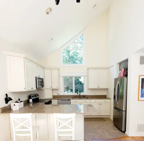 a kitchen with stainless steel appliances granite countertop a sink refrigerator and microwave