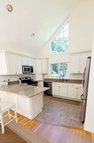 a kitchen with stainless steel appliances a white counter top space and a window