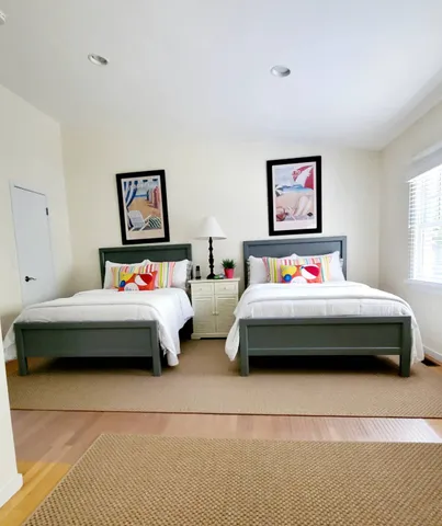 a bedroom with a bed a wall painting and a window